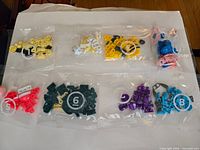 Eight sealed, numbered polybags containing assorted coloured pieces