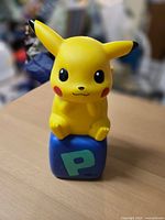 Front view of Pikachu coin bank on cube