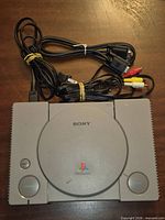 Top view of Sony PlayStation 1 console with attached power and AV cables