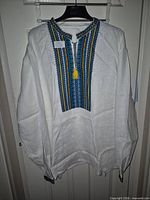 Full view of white linen vyshyvanka shirt on hanger