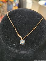 Bracelet displayed on stand showing pendant and chain