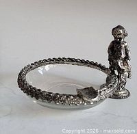 Side view showing glass dish, silver plated rim, and figurine