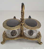 front view of brass condiment caddy showing two glass bowls, lids, spoons in place