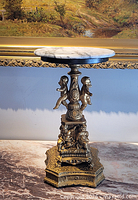 Full view of pedestal showing marble top and metal base with cherubs