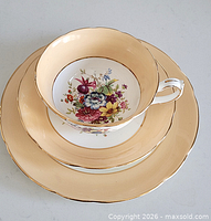 Trio stacked showing cup, saucer and plate peach borders and floral centres