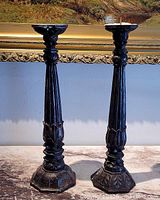 Front view of both carved wooden candlesticks showing full height, bases, and prickets