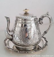 Front view teapot on plate showing engravings