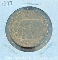 Obverse of 1897 medallion in holder, four royal profiles visible