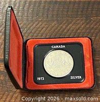 Coin displayed in open black case with red interior