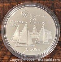Reverse of coin showing Olympic rings, sailing boats, Montreal 1976 legend and $5 denomination
