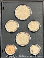 Six-coin specimen set in holder, reverse sides visible