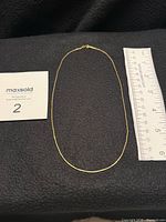 Full view of 17.5 in yellow gold snake chain necklace beside ruler for scale