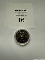 Obverse view of coin inside protective capsule with lot identifier card