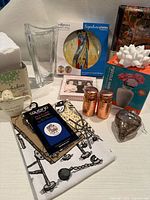 Group shot of all items showing vase, plates box, puzzle vase kit, tea towel, copper shakers, ornament, baby box, coasters