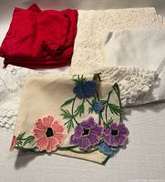 Group of red napkins, lace pieces and embroidered cloth