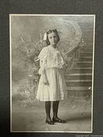 Full-length portrait of young girl on grey mount