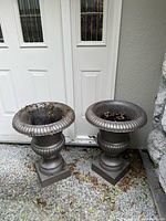 pair of cast iron urn planters side by side