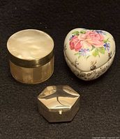Front view of three trinket boxes showing shapes and materials