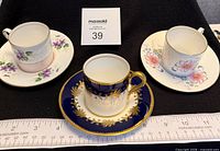 Group shot of three espresso cups, one saucer visible, ruler for scale