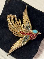 Front view of gold-tone bird brooch showing multicolour rhinestones and turquoise cabochon