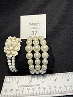 Both cuffs on display pillow with ruler for scale