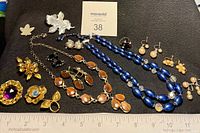 Full lot overview showing necklaces, earrings and brooches with scale