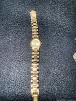 Gold-tone bracelet watch with round case (likely Seiko)