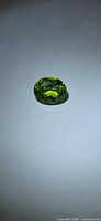 Top view of vivid green oval checkerboard-cut Peridot gemstone