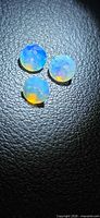Three round faceted opals showing play-of-color