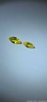 Two yellow marquise sapphires on neutral background