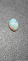 Front view of oval rutile opal showing play-of-colour