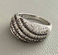 Front view of domed white gold ring showing alternating rows of black and white diamonds