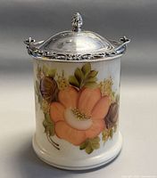 Front view of hand-painted glass biscuit jar showing floral design and silver-plated lid