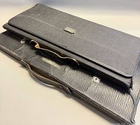 Two black leatherette carrying cases stacked
