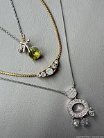 Three necklaces laid flat showing pendants and chains