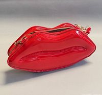 Front angled view showing red lip-shaped bag and zipper