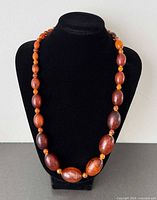 Necklace displayed on bust showing bead graduation and colour