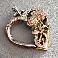 Front view of heart-shaped pendant showing crystals and enamel roses