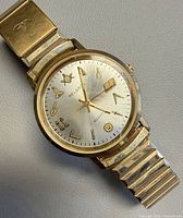 Front view of watch showing dial, symbols, and band