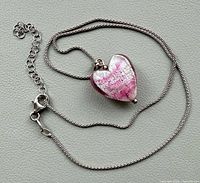 Full view of necklace laid out showing chain, clasp and heart pendant