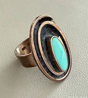 Front view showing turquoise cabochon and concentric design