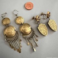 Both earring pairs beside penny for scale