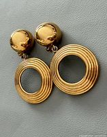 Front view showing gold-tone domed studs with open ring drops