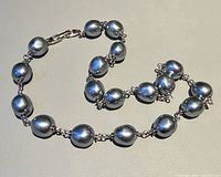 Necklace laid flat showing full strand, bead shape, clasp, and linking hardware