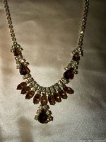 Close view of necklace center showing brown teardrop stones and clear rhinestone surrounds