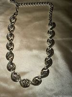 Full view of silver-tone twisted link choker necklace with extender
