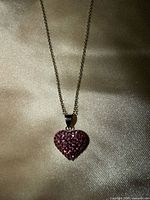 Close-up of heart pendant showing pink stones and bail on chain