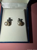 Front view of earrings showing marcasite crosses and pearl drops in box