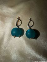 Front view of both earrings showing teal beads and silver-tone hooks