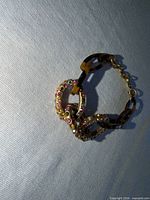 Bracelet showing tortoiseshell links and rhinestone loops